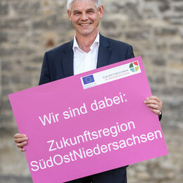 Bild von Oberbürgermeister Frank Klingebiel mit einem Plakat der Zukunftsregion