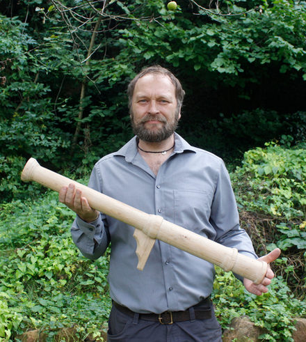 Dr. Bastian Asmus mit dem von ihm gefertigten Holzmodell des Laufs der Hakenbüchse