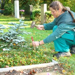 Eine Mitarbeiterin des SRBs markiert eine Grabstelle.
