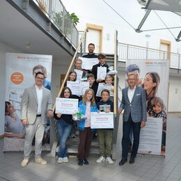 Lehrer Xaver Wiese vom Kranich-Gymnasium (hinten oberste Treppenstufe), BKK-Vorstand Matthias Frenzel  (rechts) und Dr. Marcel Dierich (links, BKK Bereich Gesundheitsförderung) mit den Lebenstedter Siegerinnen und Siegern des SCHULRADELN 2025. 1. Reihe von links nach rechts: Anastasia Sorocean, Finja Urbas, Mattis Treutheit; 2. Reihe von links nach rechts: Lisbeth Scholz, Elias Poloczek, Luca Gruner, 3. Reihe Anabel Metze und Manuel Deimling.