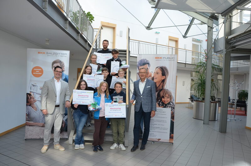 Lehrer Xaver Wiese vom Kranich-Gymnasium (hinten oberste Treppenstufe), BKK-Vorstand Matthias Frenzel  (rechts) und Dr. Marcel Dierich (links, BKK Bereich Gesundheitsförderung) mit den Lebenstedter Siegerinnen und Siegern des SCHULRADELN 2025. 1. Reihe von links nach rechts: Anastasia Sorocean, Finja Urbas, Mattis Treutheit; 2. Reihe von links nach rechts: Lisbeth Scholz, Elias Poloczek, Luca Gruner, 3. Reihe Anabel Metze und Manuel Deimling.