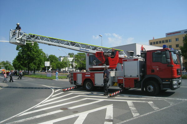 Ein Leiterwagen der Feuerwehr. Im Korb des Auslegers steht ein Feuerwehrmann.