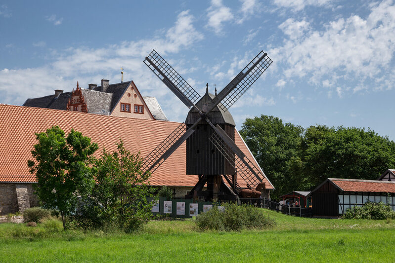 Auf dem Bild ist im Vordergrund die Osterlinder Bockwindmühle zu sehen. Im Hintergrund das Ausstellungsgebäude Schafstall und dahinter Giebel des Schlosses Salder.
