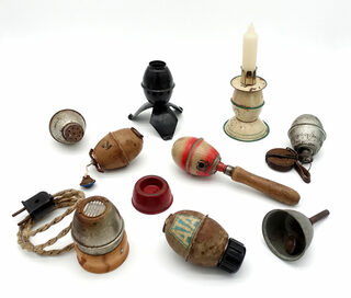Gegenstände, die aus einer Eihandgranate gefertigt wurden: Kerzenständer, Lot, Babyrassel, Waschmittelbehälter, Flaschenverschluss, Glocke, Rauchverzehrer