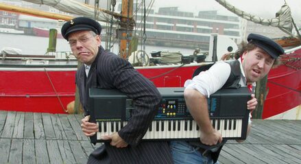 Lui und Fiete zerren an einem Keyboard. Im Hintergrund ein Schiff.